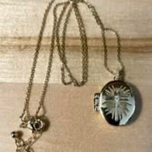 Gold locket with a cross engraved on it